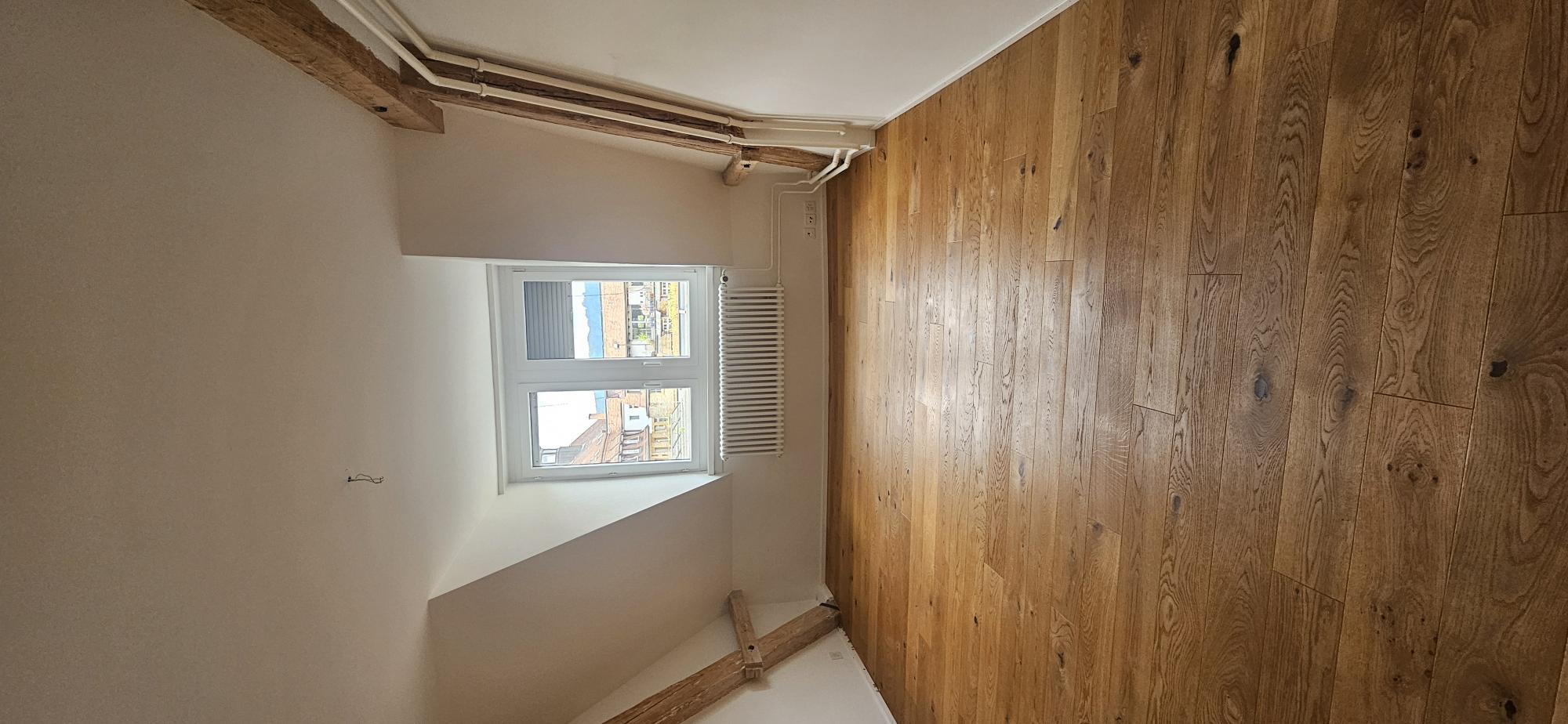 Dachzimmer mit Holzboden und Fenster
