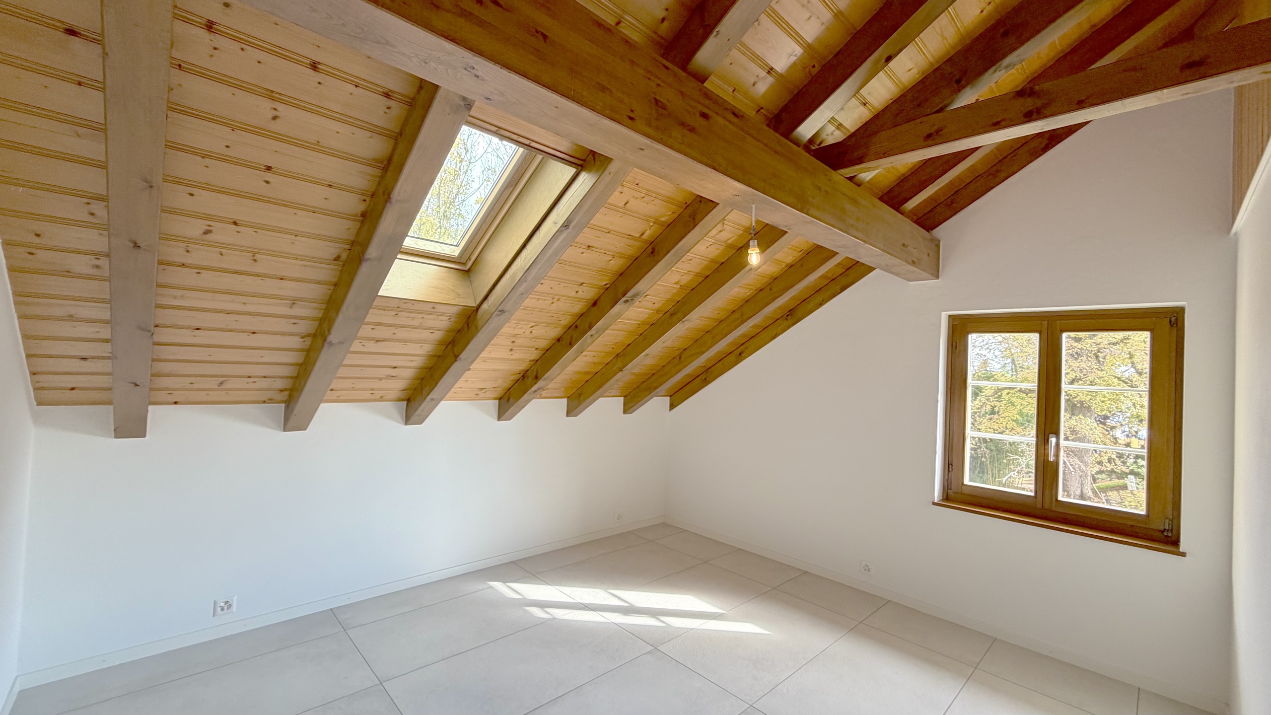 Ausgebauter Dachraum mit sichtbarer Holzbalkendecke