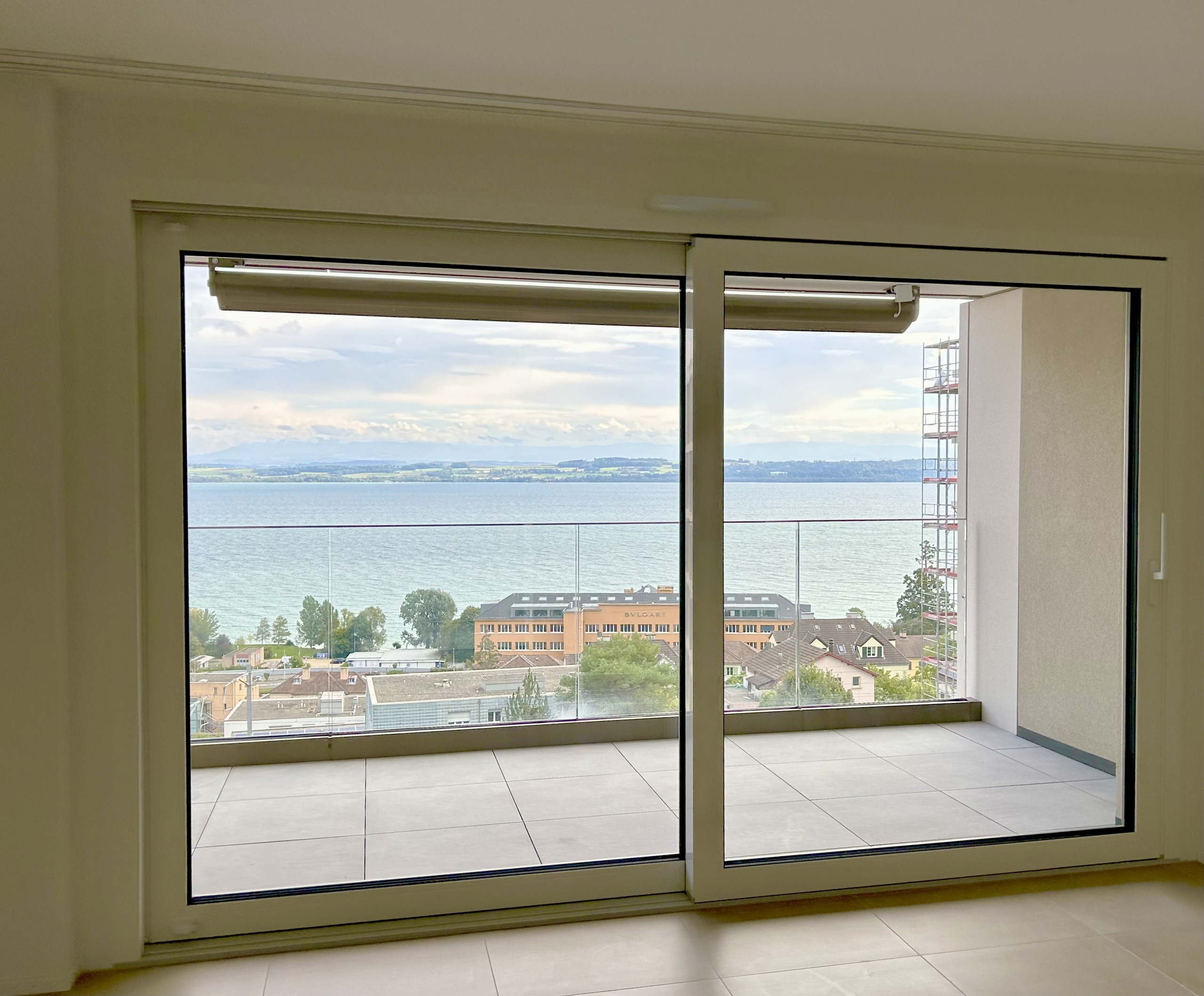 Wohnraum mit großflächiger Verglasung und Seeblick