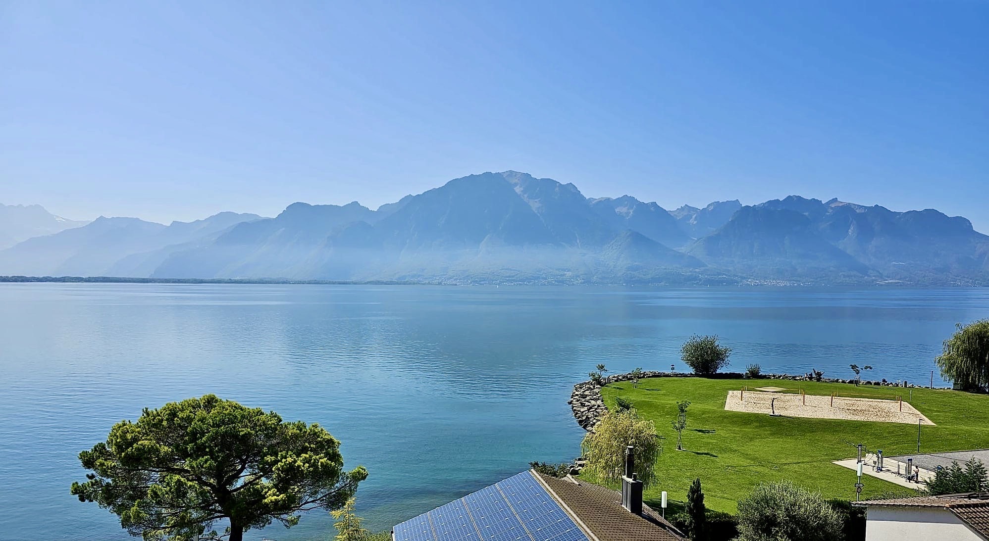 Seeblick mit Bergpanorama und Garten am Ufer