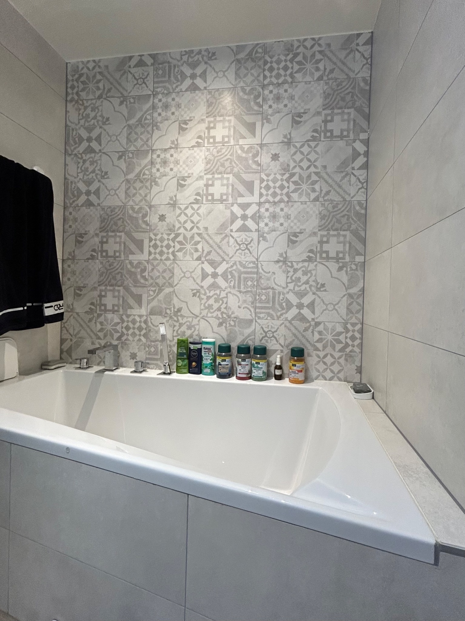 Badezimmer mit Badewanne und Fliesenwand