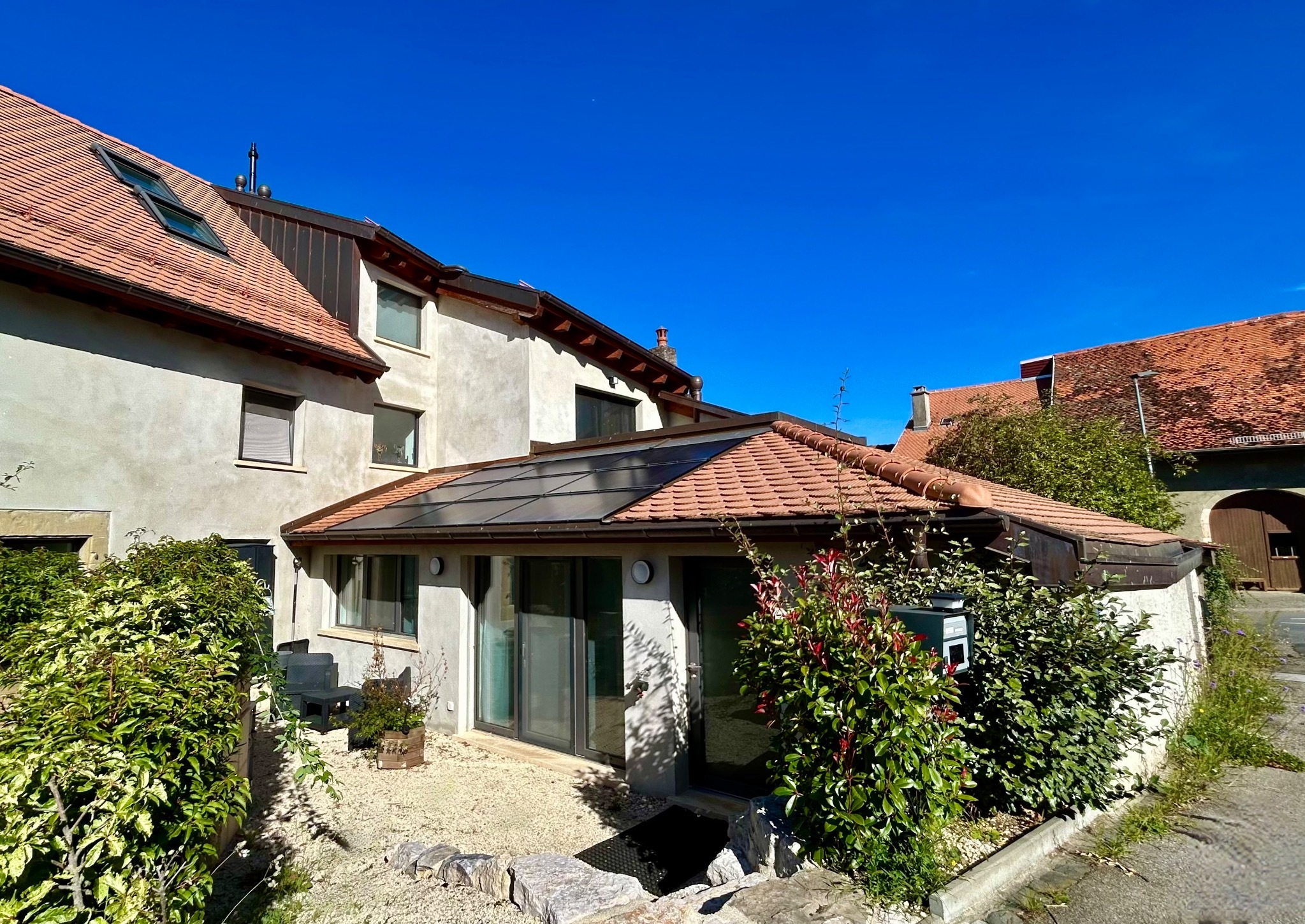 Außenansicht eines mediterran wirkenden Wohnhauses mit Terrakotta-Dach
