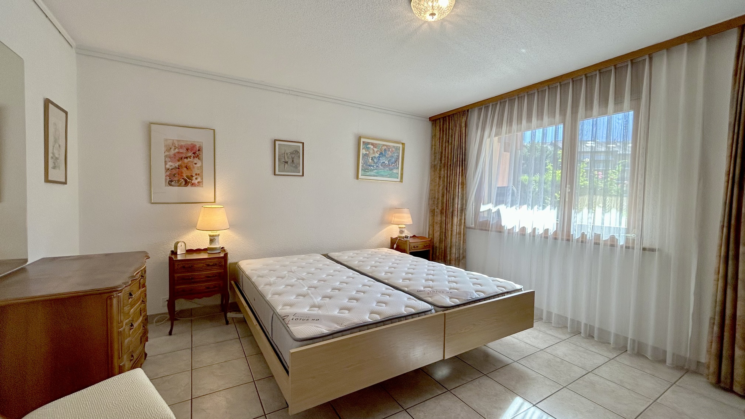 Schlafzimmer mit großem Fenster und zwei Betten