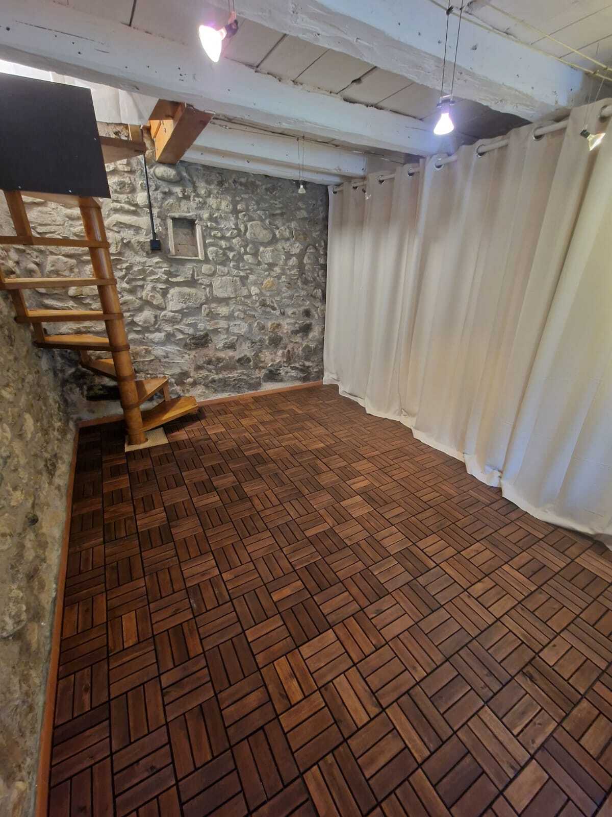 Kleiner Raum mit Natursteinwand und Holztreppe