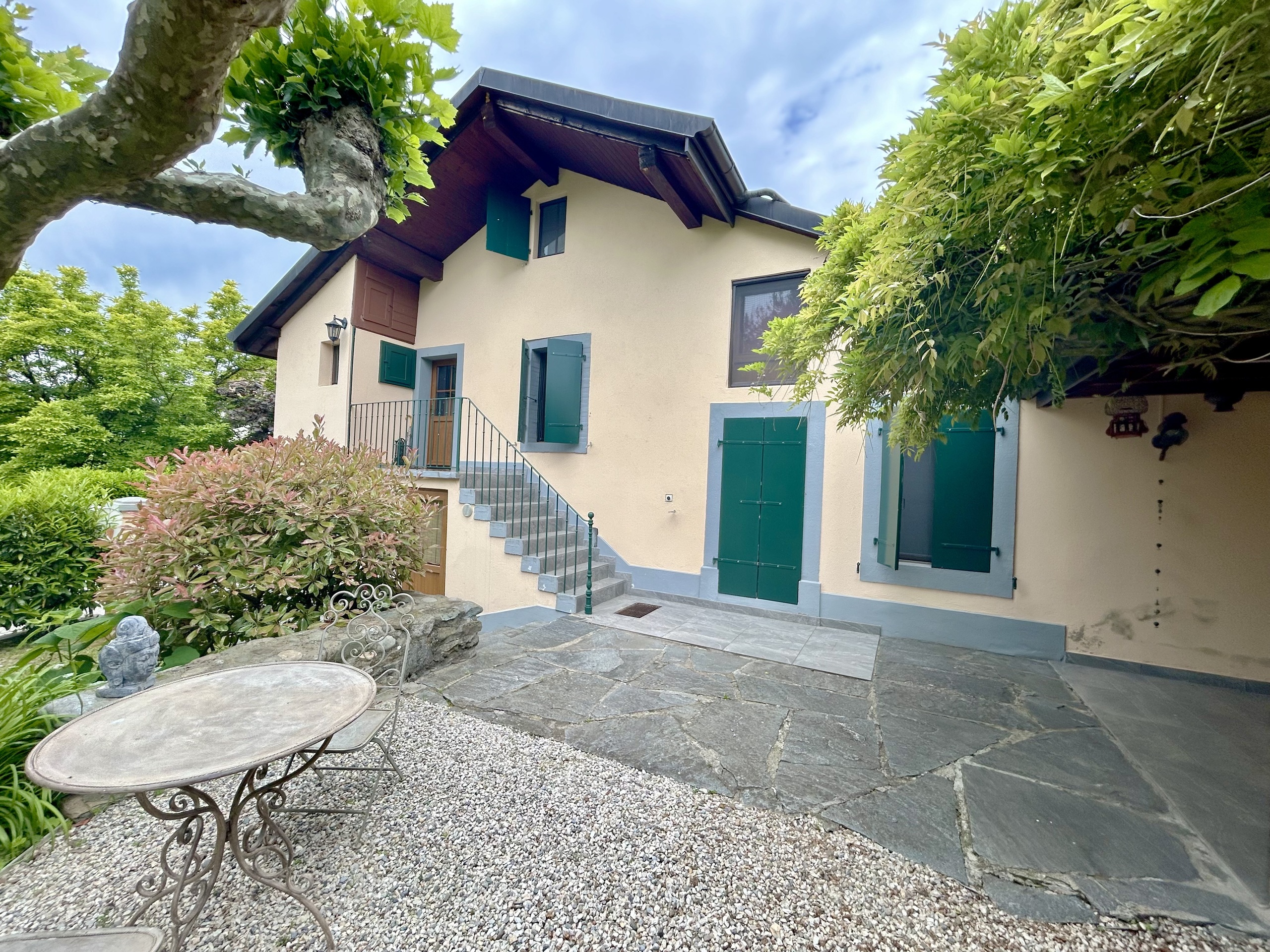 Charmanter Außenbereich eines Hauses mit Terrasse und Garten