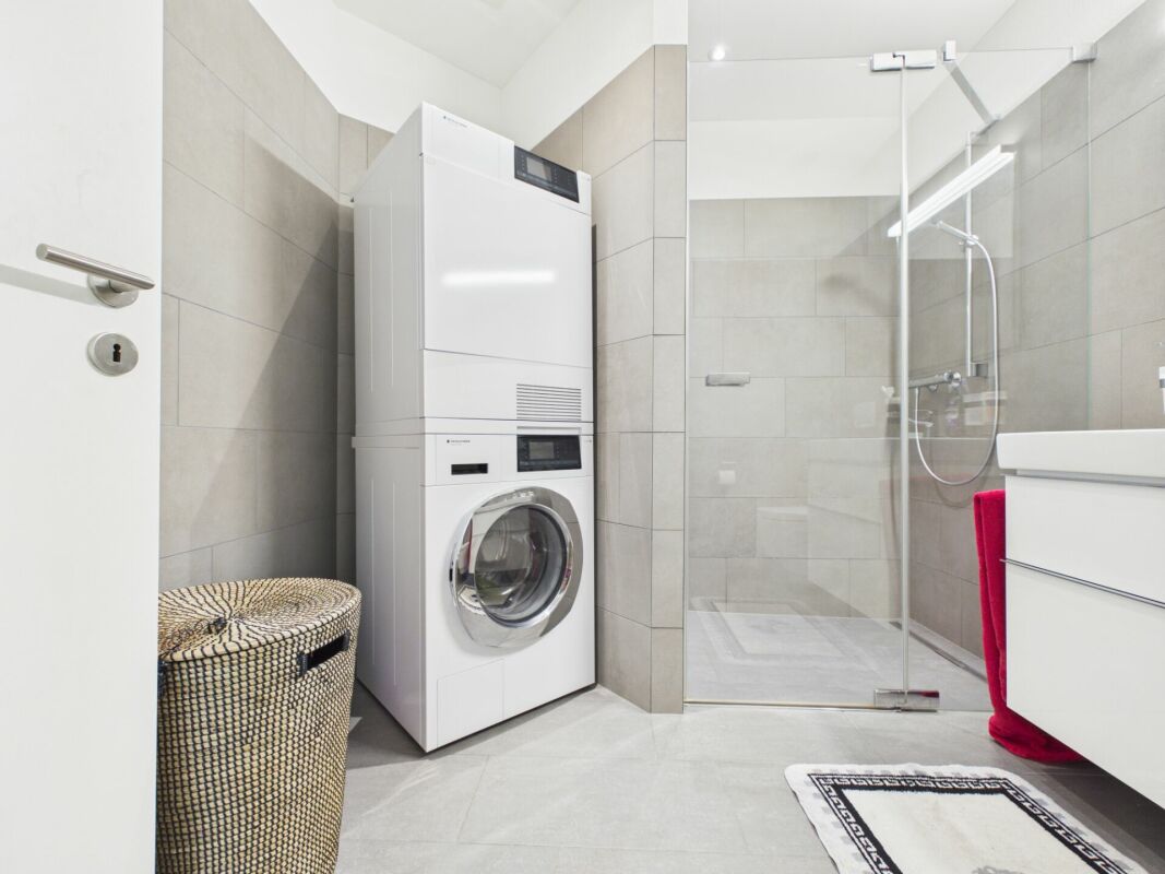 Modernes Bad mit Dusche und Waschtrockner