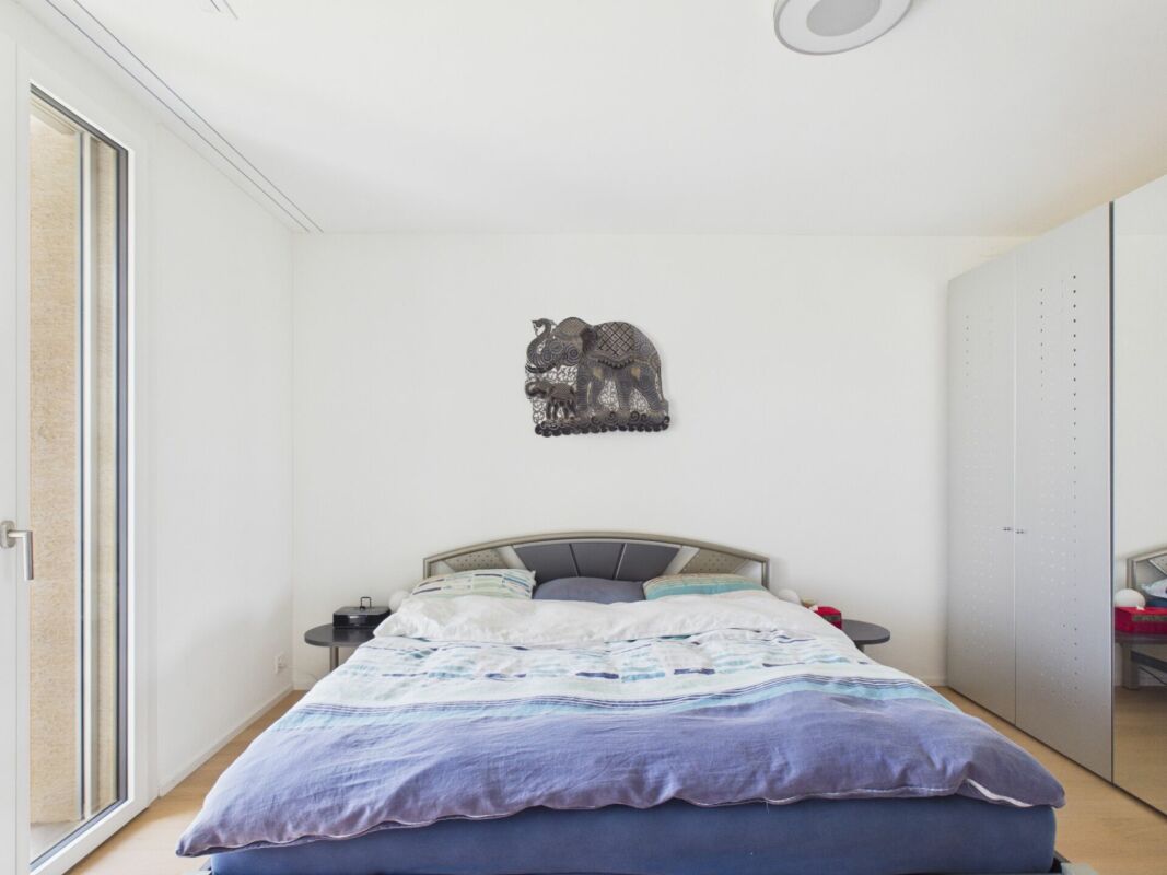 Helles Schlafzimmer mit Doppelbett und Einbauschrank
