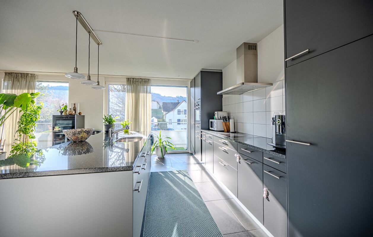 Moderne Küche mit Insel und Balkonblick