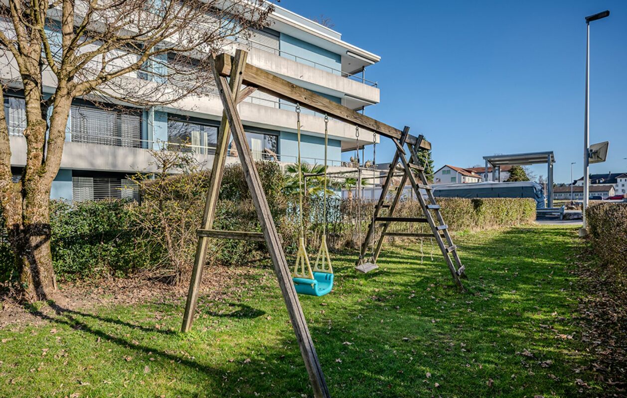 Außenbereich mit Spielgerüst vor moderner Wohnanlage
