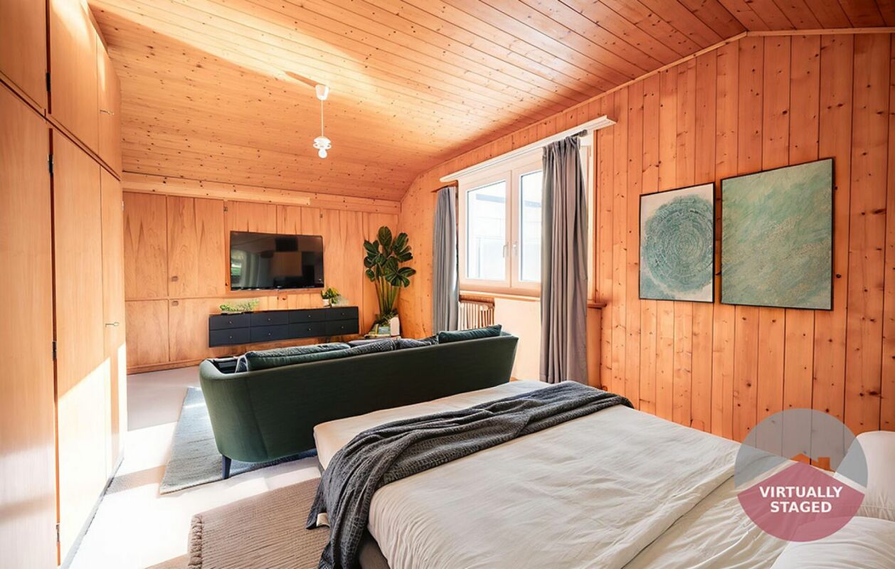 Gemütliches, holzverkleidetes Schlafzimmer mit Wohnbereich