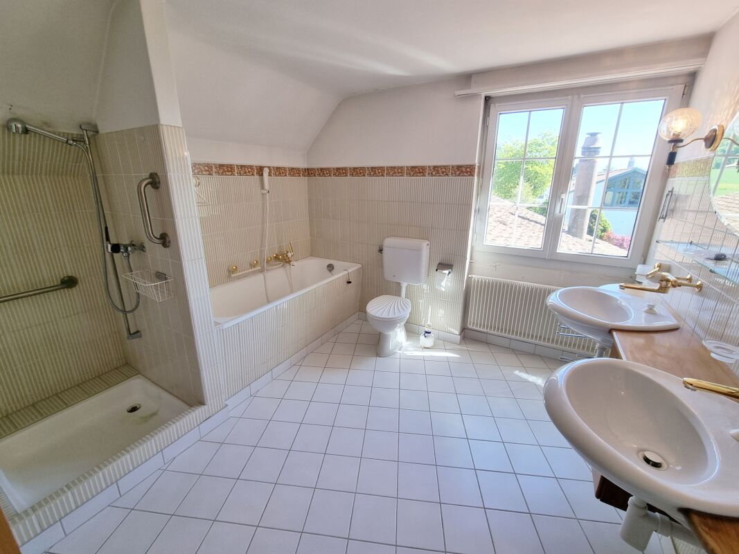 Badezimmer mit Badewanne und Doppelwaschbecken