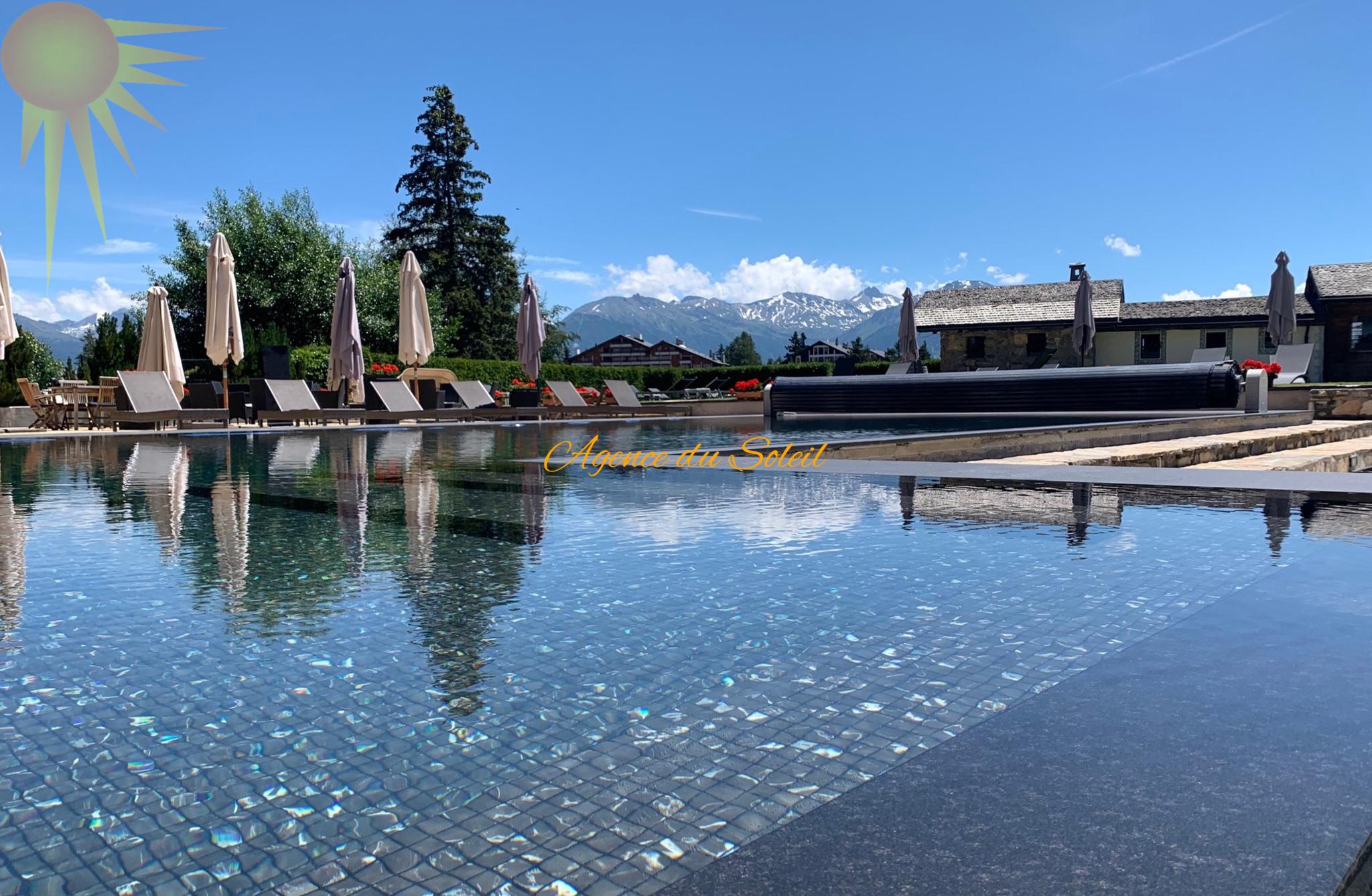 Außenpool mit Liegen und Bergblick
