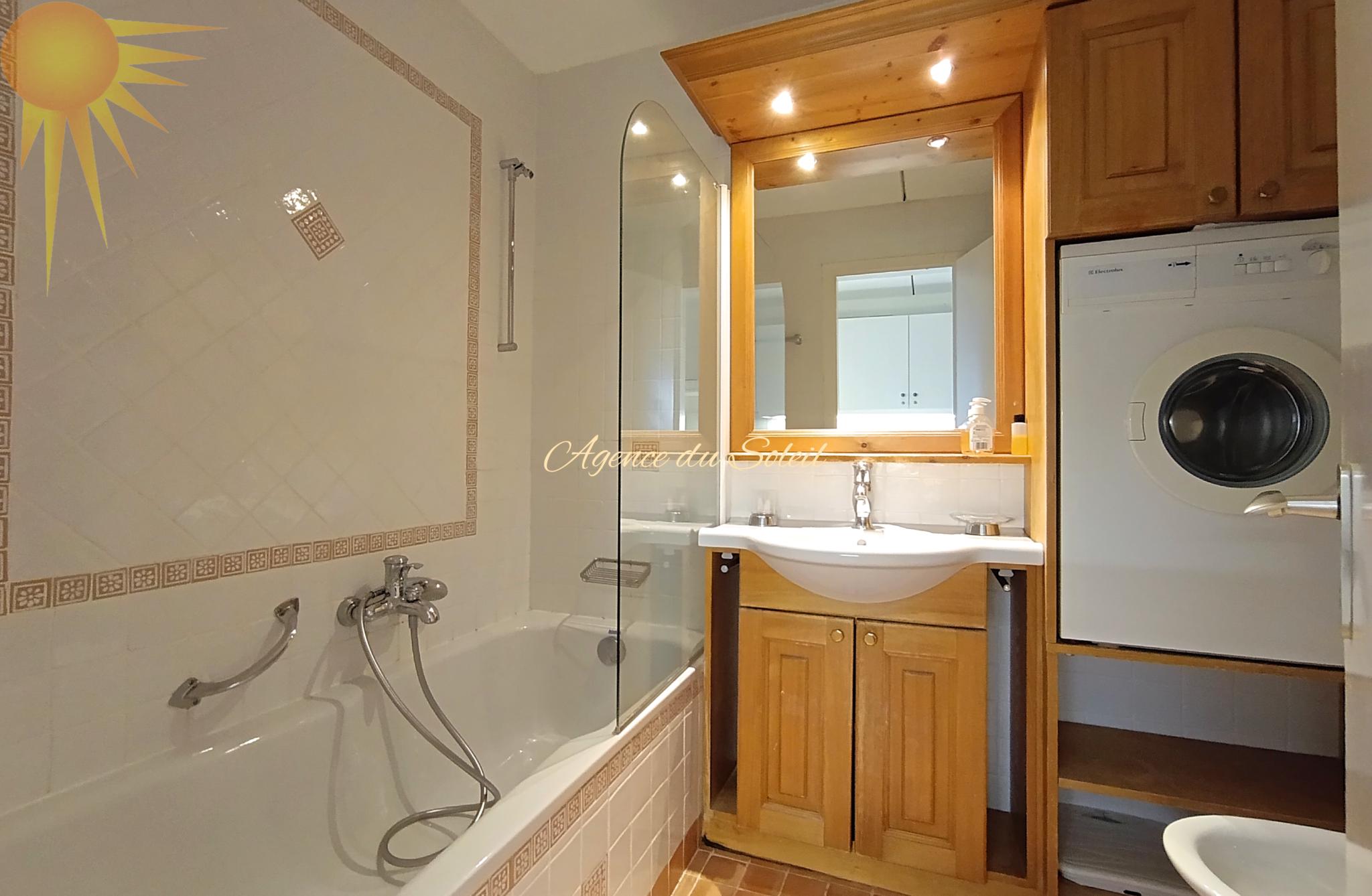 Badezimmer mit Badewanne und Waschmaschine