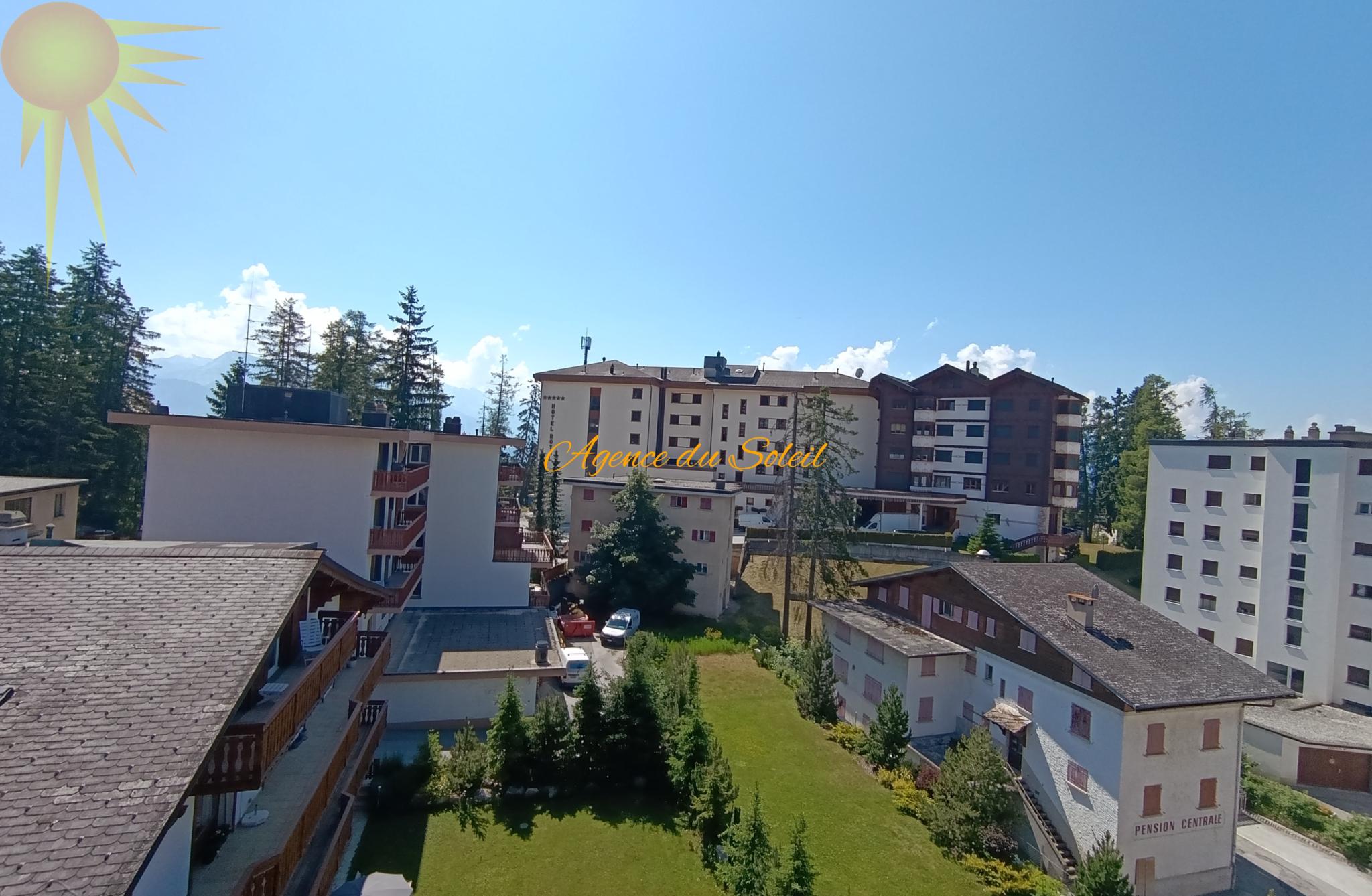 Blick über alpine Hotel- und Wohngebäude mit Grünfläche