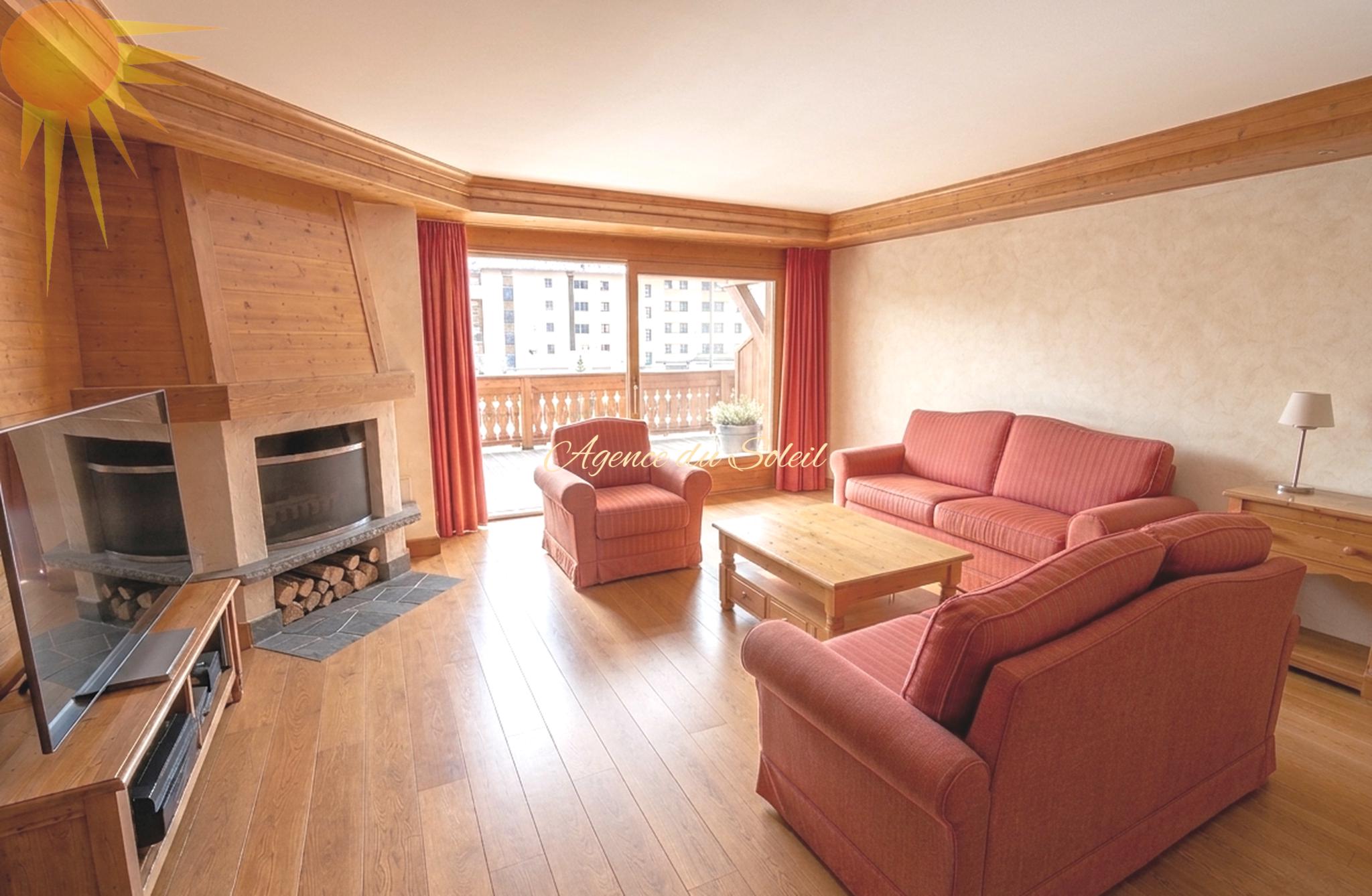 Gemütliches Wohnzimmer mit Kamin und Balkonzugang