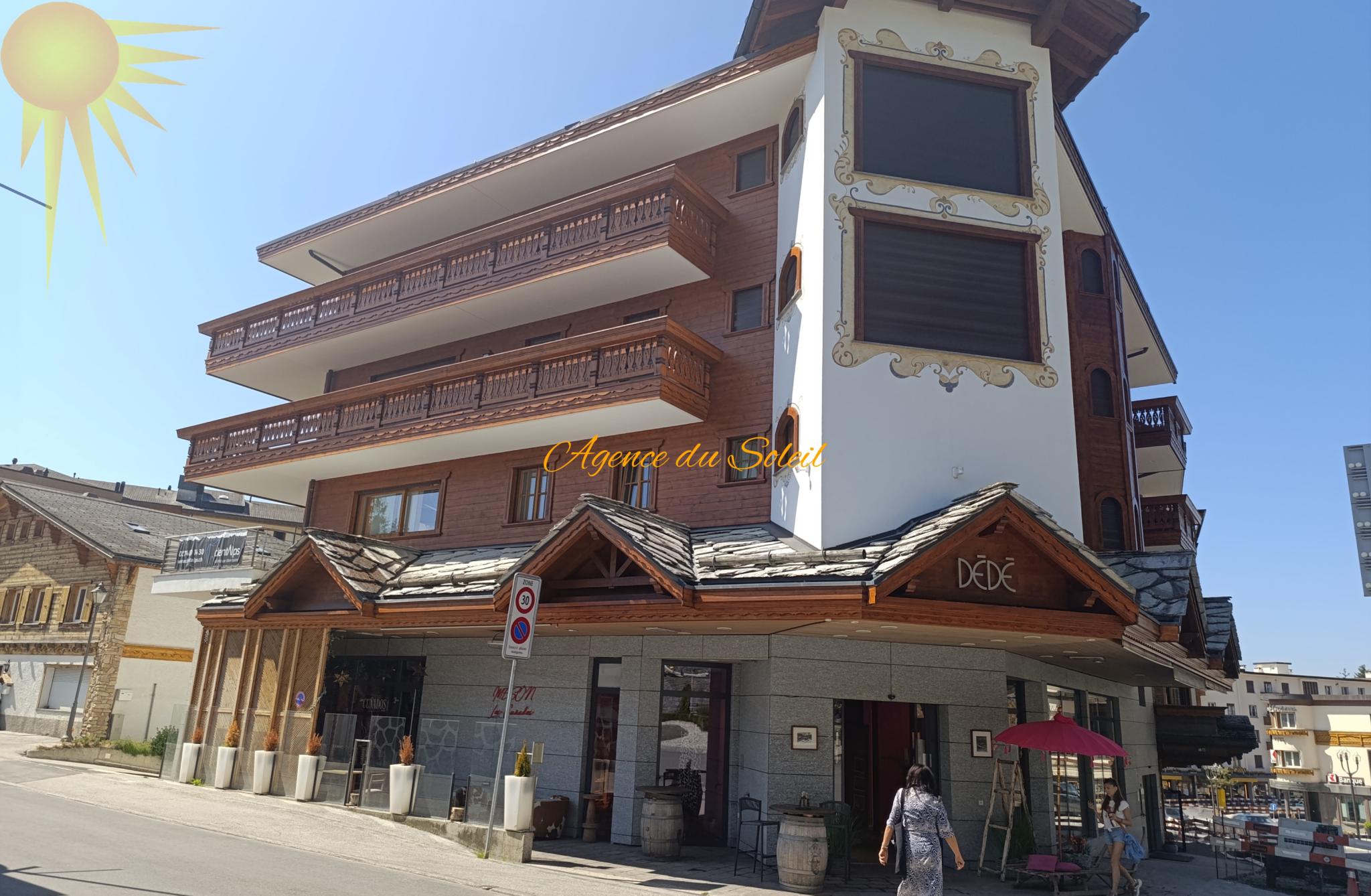 Alpenchalet-/Hotelgebäude an sonniger Straße