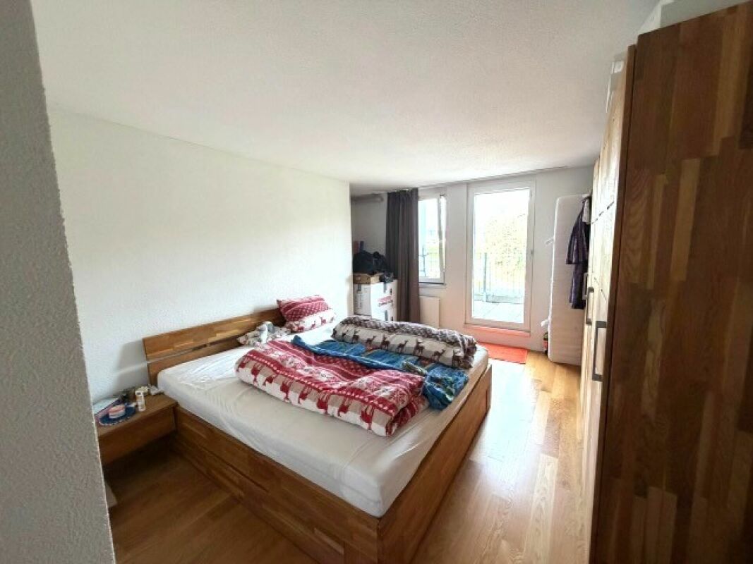 Modernes Schlafzimmer mit Holzbett und Balkonzugang