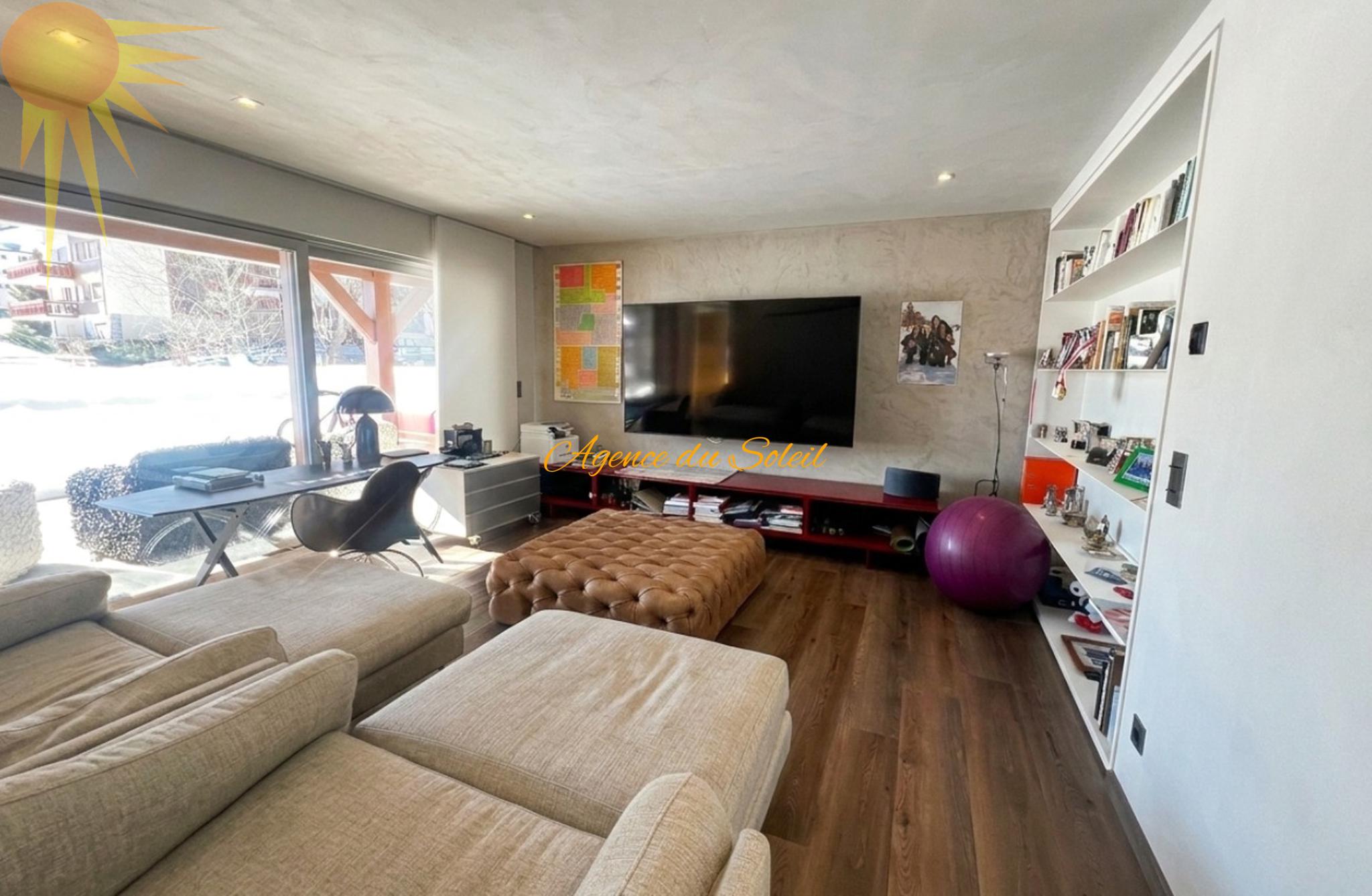 Helles Wohnzimmer mit großer Fensterfront und TV-Wand