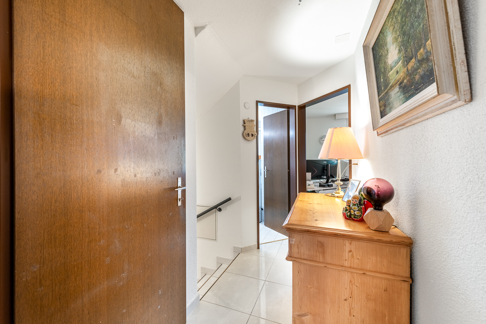 Heller Flur mit Holzkommode