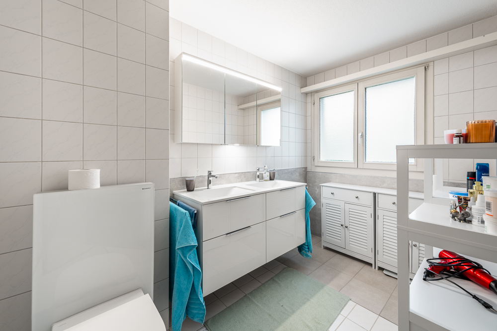 Helles, modernes Badezimmer mit Doppelwaschtisch und Fenster