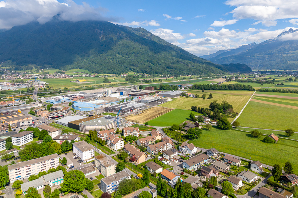 Luftaufnahme einer Stadt am Alpenrand