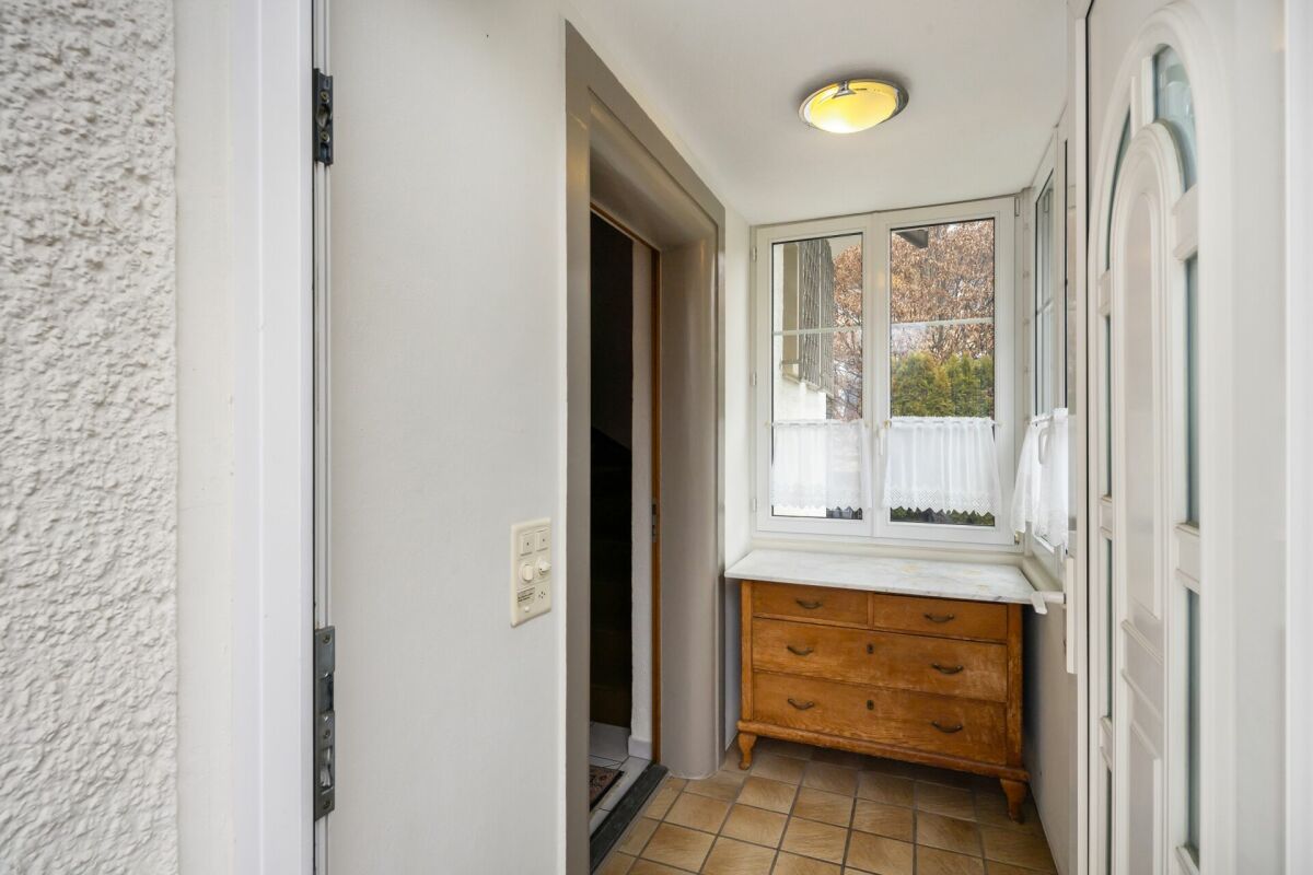 Heller Eingangsbereich mit Fenster und Kommode