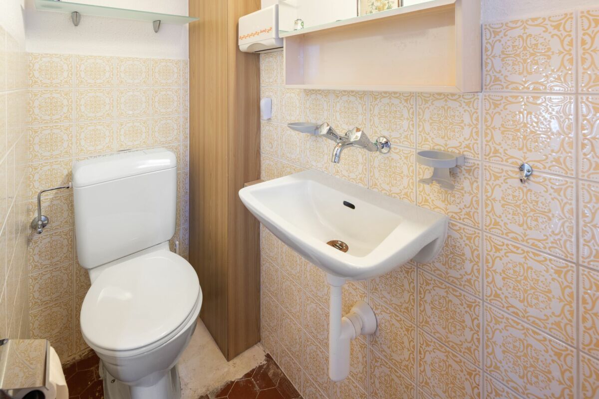 Gäste-WC mit Waschbecken und Toilette
