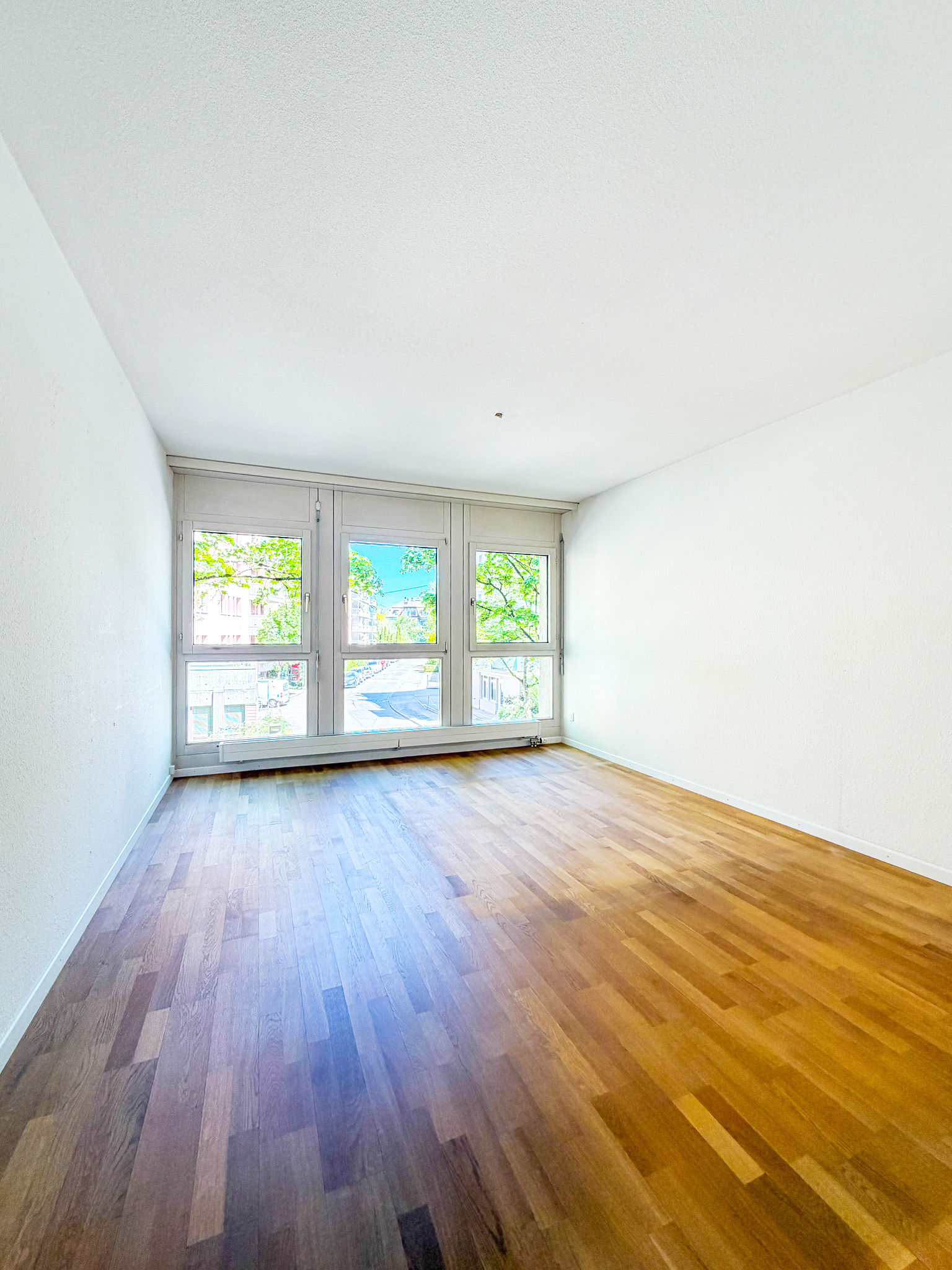Leerer heller Wohnraum mit großen Fenstern