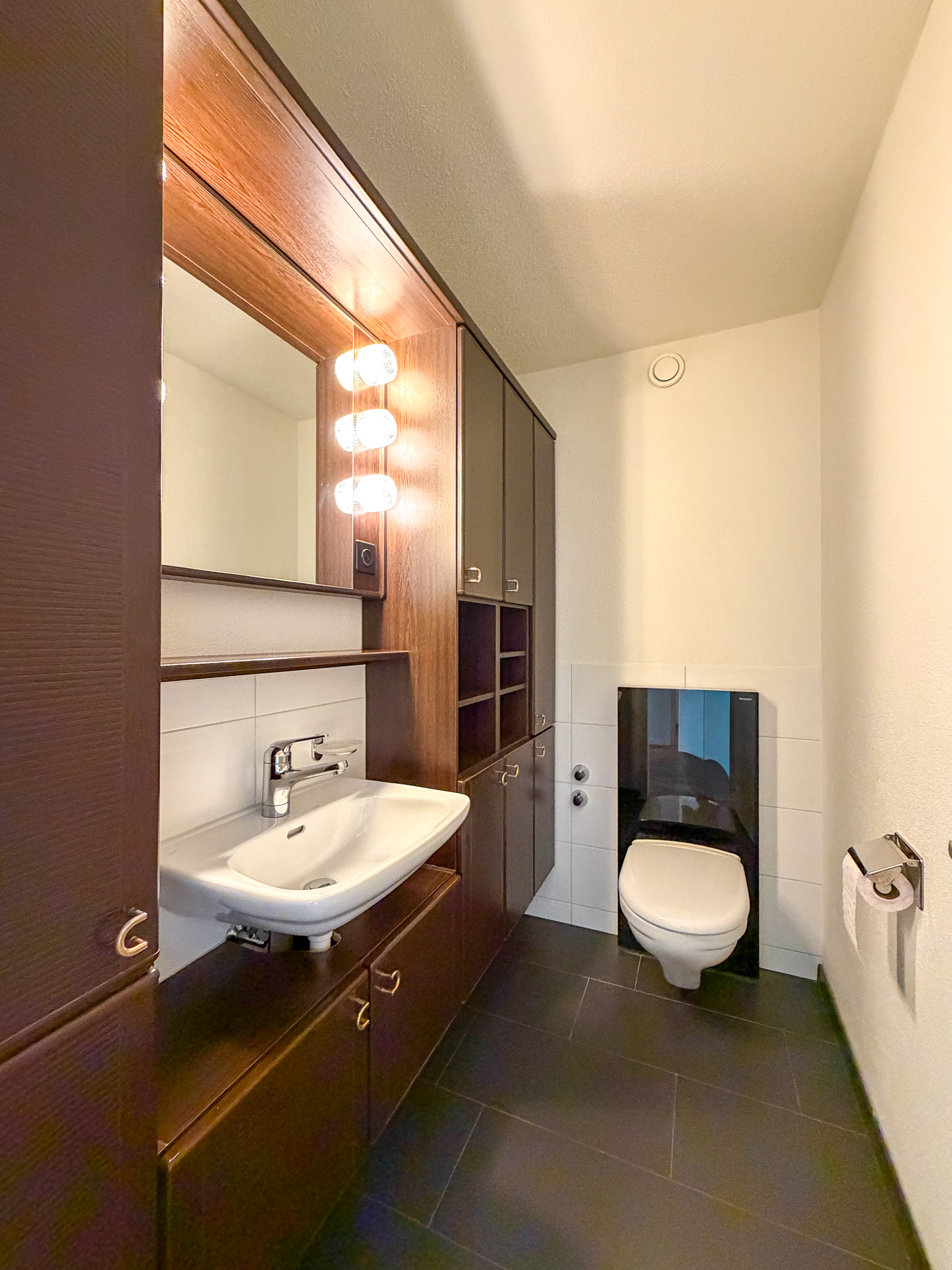 Gäste-WC mit dunklen Holzmöbeln