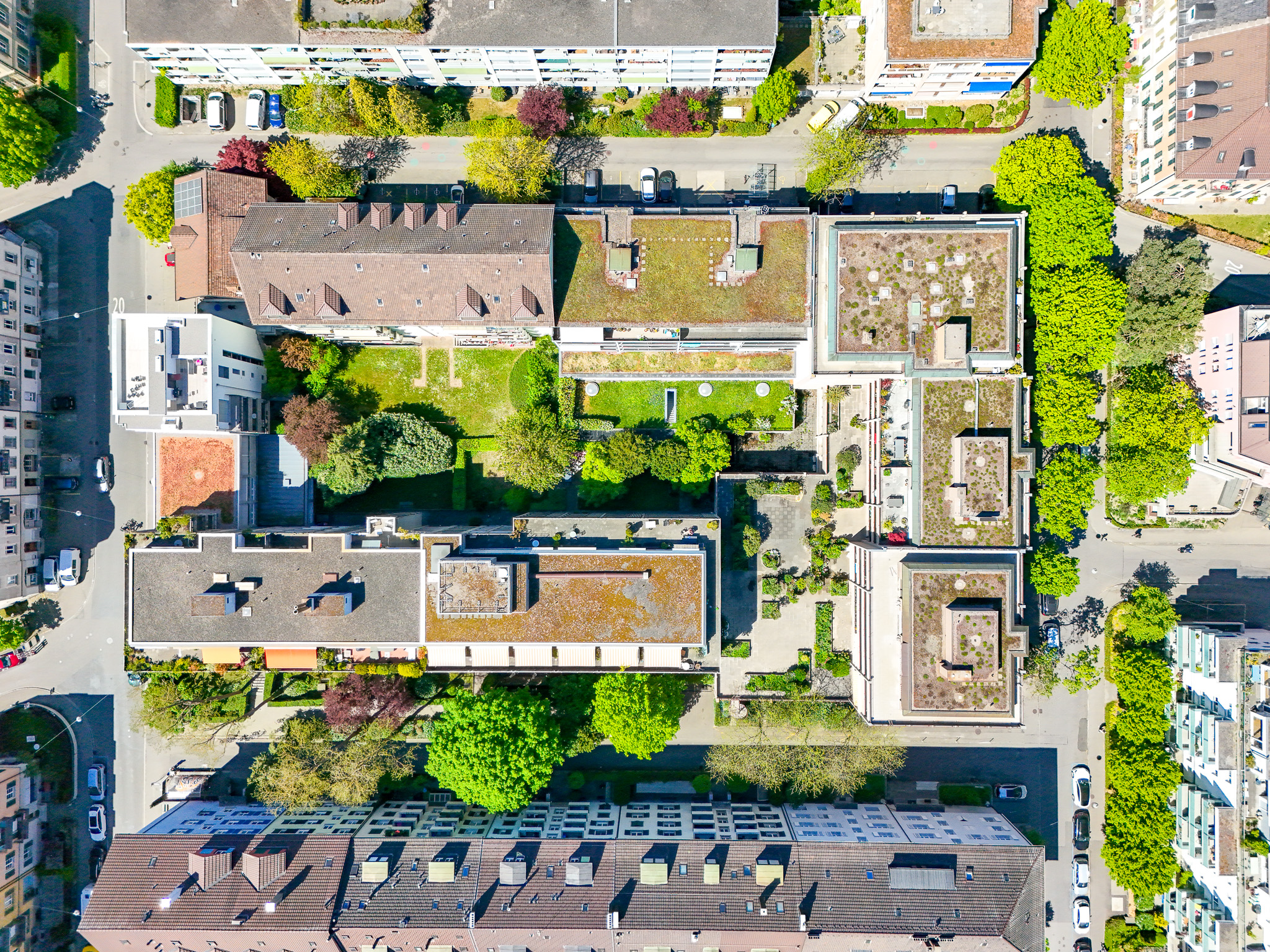 Luftaufnahme eines Wohnblocks mit Innenhof und umliegenden Stadtgebäuden