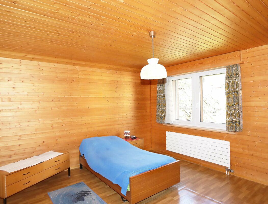 Holzverkleidetes Schlafzimmer mit Einzelbett