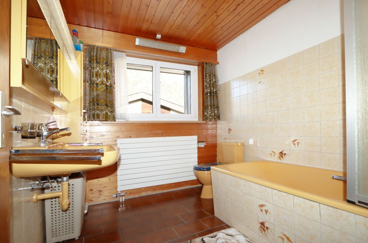 Kleines Bad mit Badewanne und Holzdecke