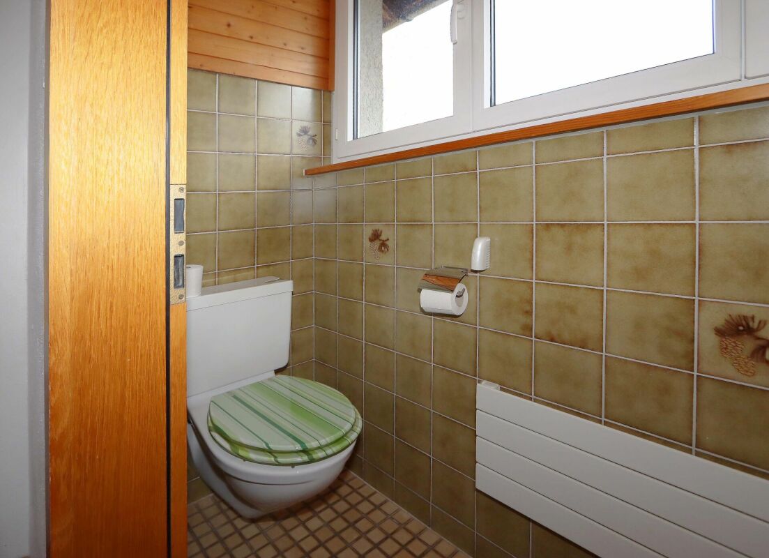 Kleines WC mit Fliesen und Holzdetails