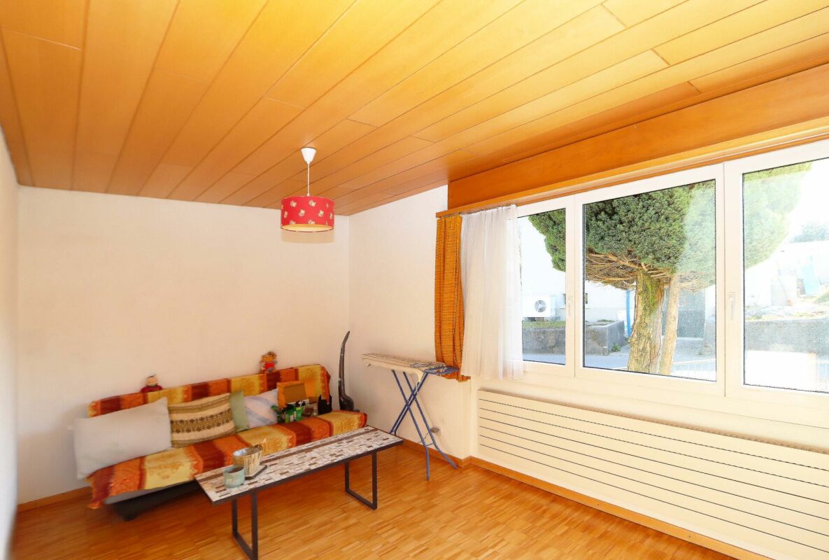 Wohnzimmer mit Holzdecke und großem Fenster