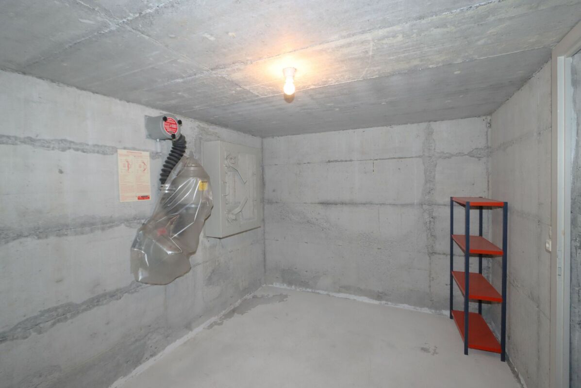 Kellerraum mit Betonwänden und Lagerregal