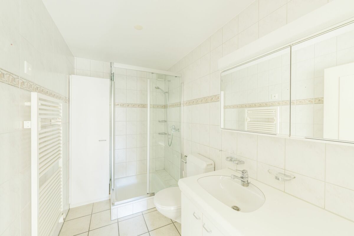 Helles Badezimmer mit Dusche und Spiegelschrank
