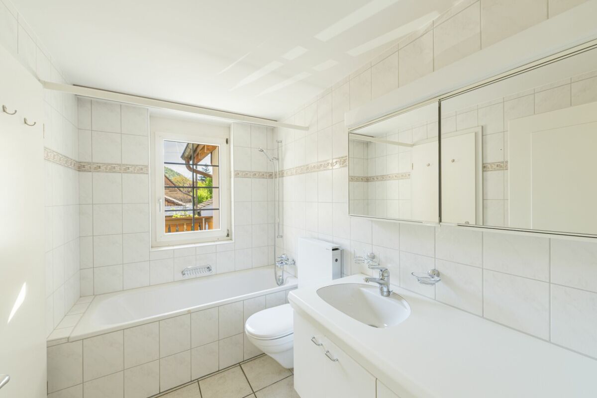 Helles Badezimmer mit Wanne, Waschbecken und Spiegelschrank