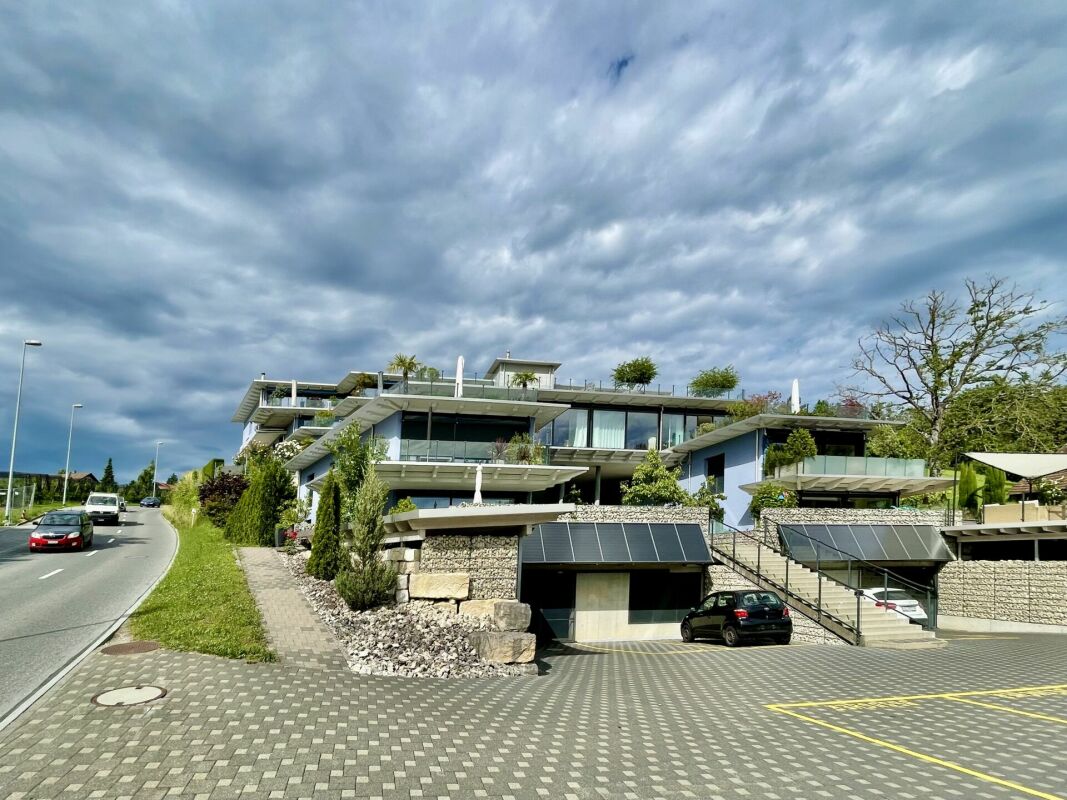 Modernes Wohngebäude mit Dachterrassen und Garagenzufahrt