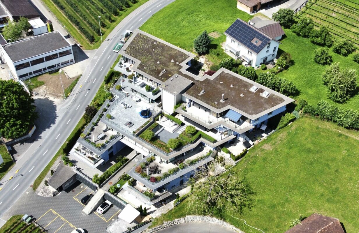 Luftaufnahme eines modernen Wohnkomplexes mit Terrassen und Photovoltaik