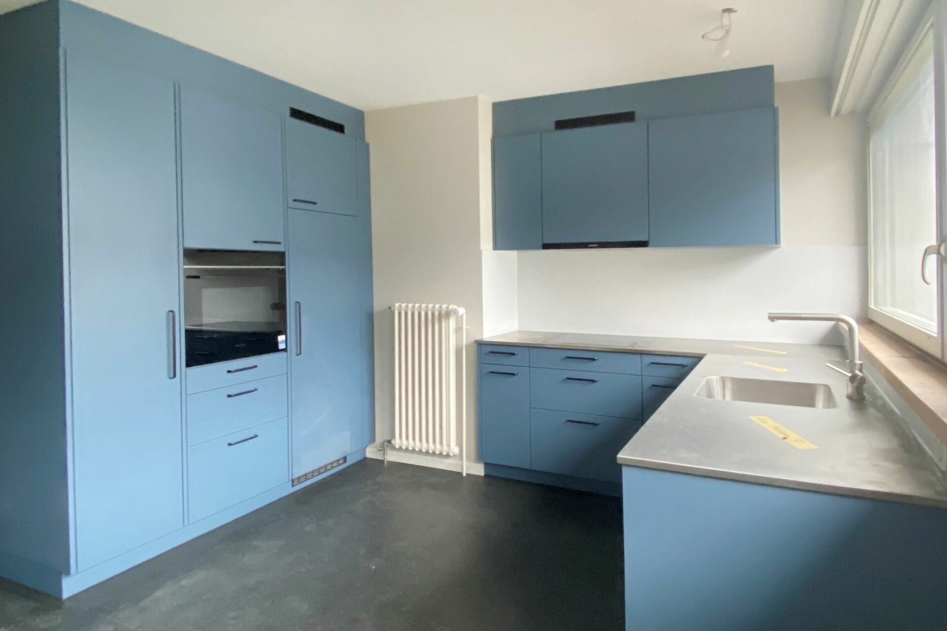 Moderne blaue Küche mit Edelstahlarbeitsplatte