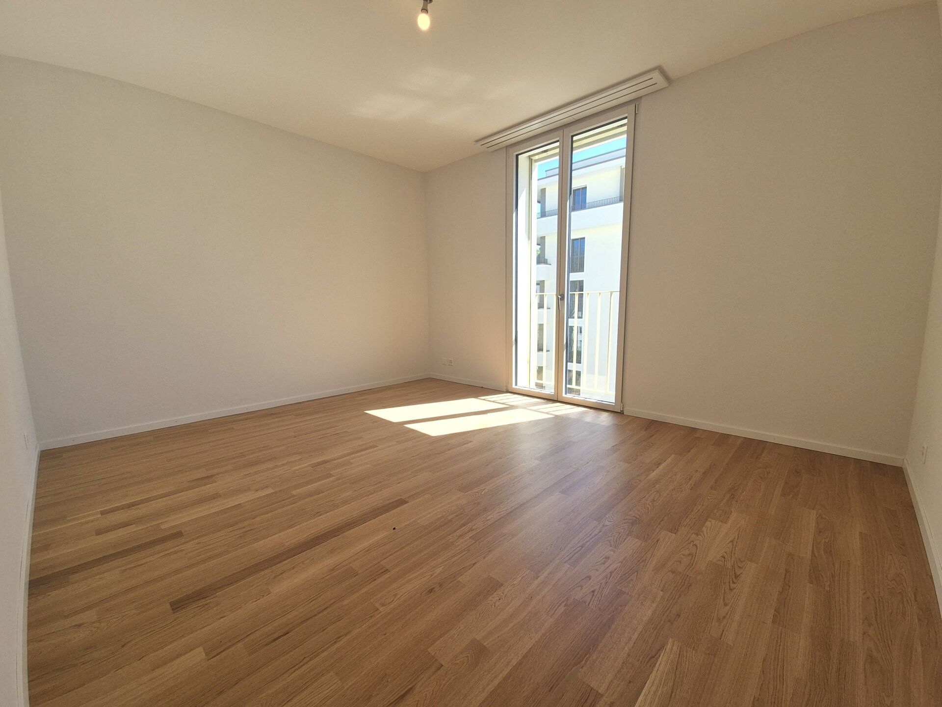 Leeres helles Zimmer mit Balkonfenster