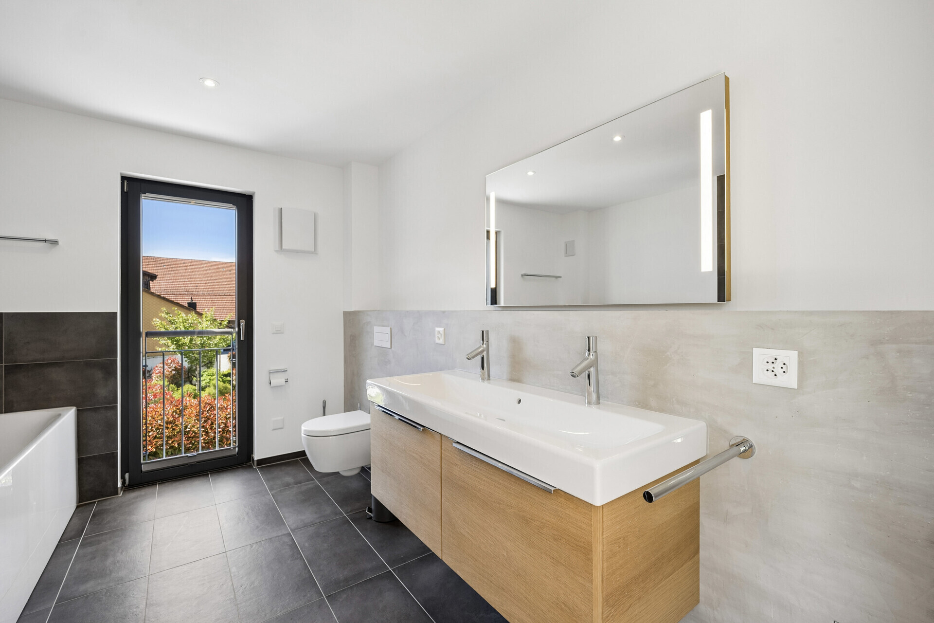 Modernes Badezimmer mit Doppelwaschtisch und Balkonblick