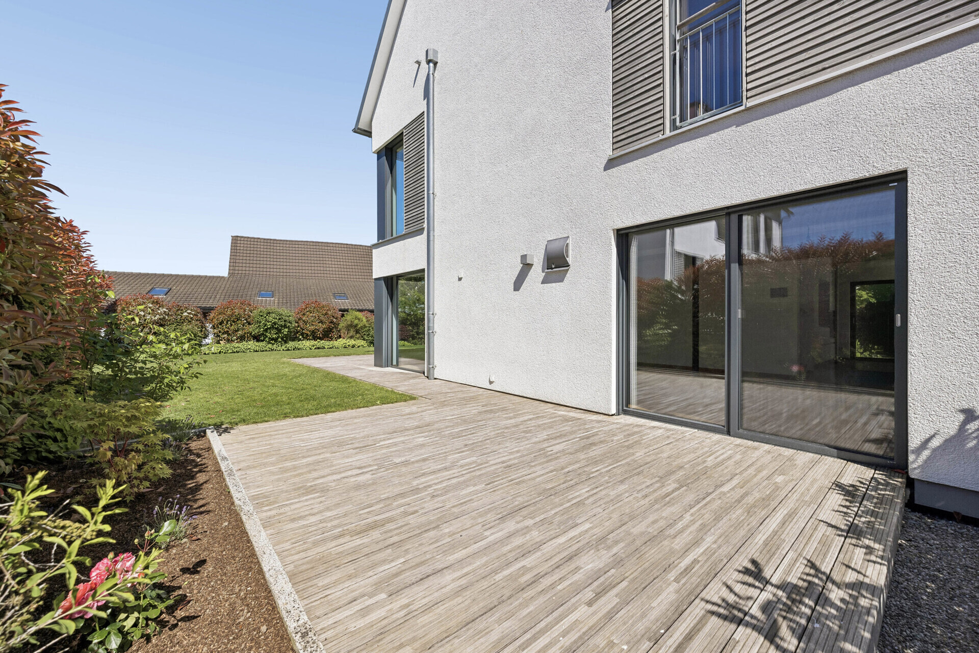 Garten und Terrassenbereich an moderner Hausfassade