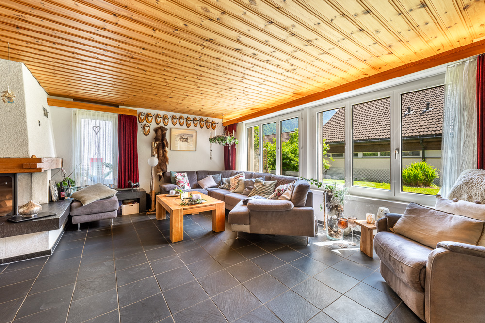 Heller Wohnraum mit Kamin und großer Fensterfront