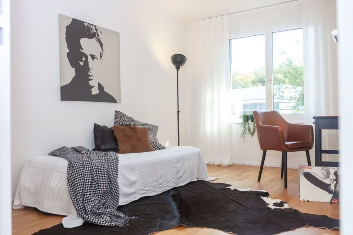 Helles, minimalistisch gestyltes Schlafzimmer mit Sitzbereich