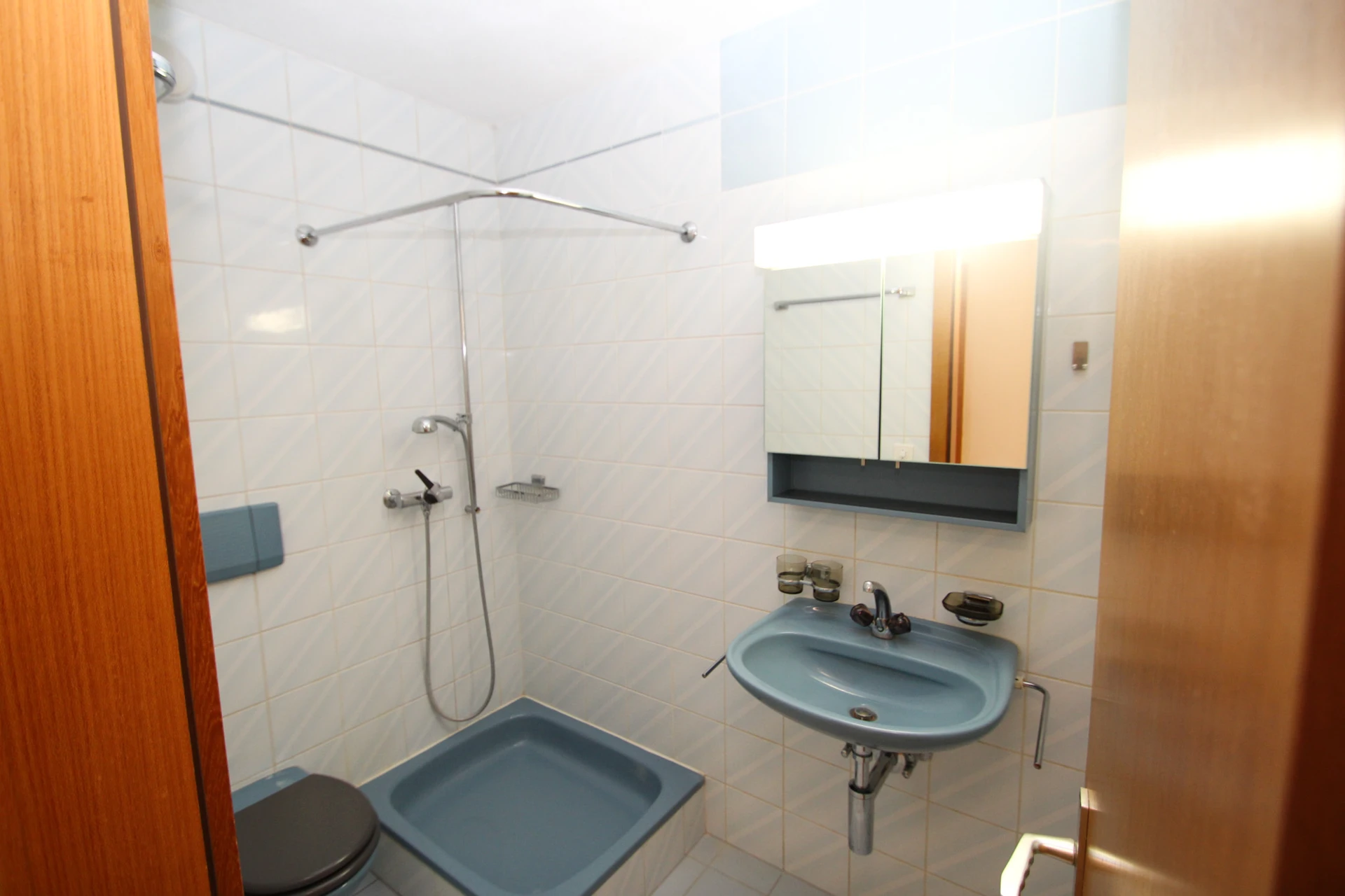 Kleines Badezimmer mit blauem Sanitärbereich
