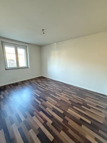 Leerer heller Raum mit neuem Laminatboden