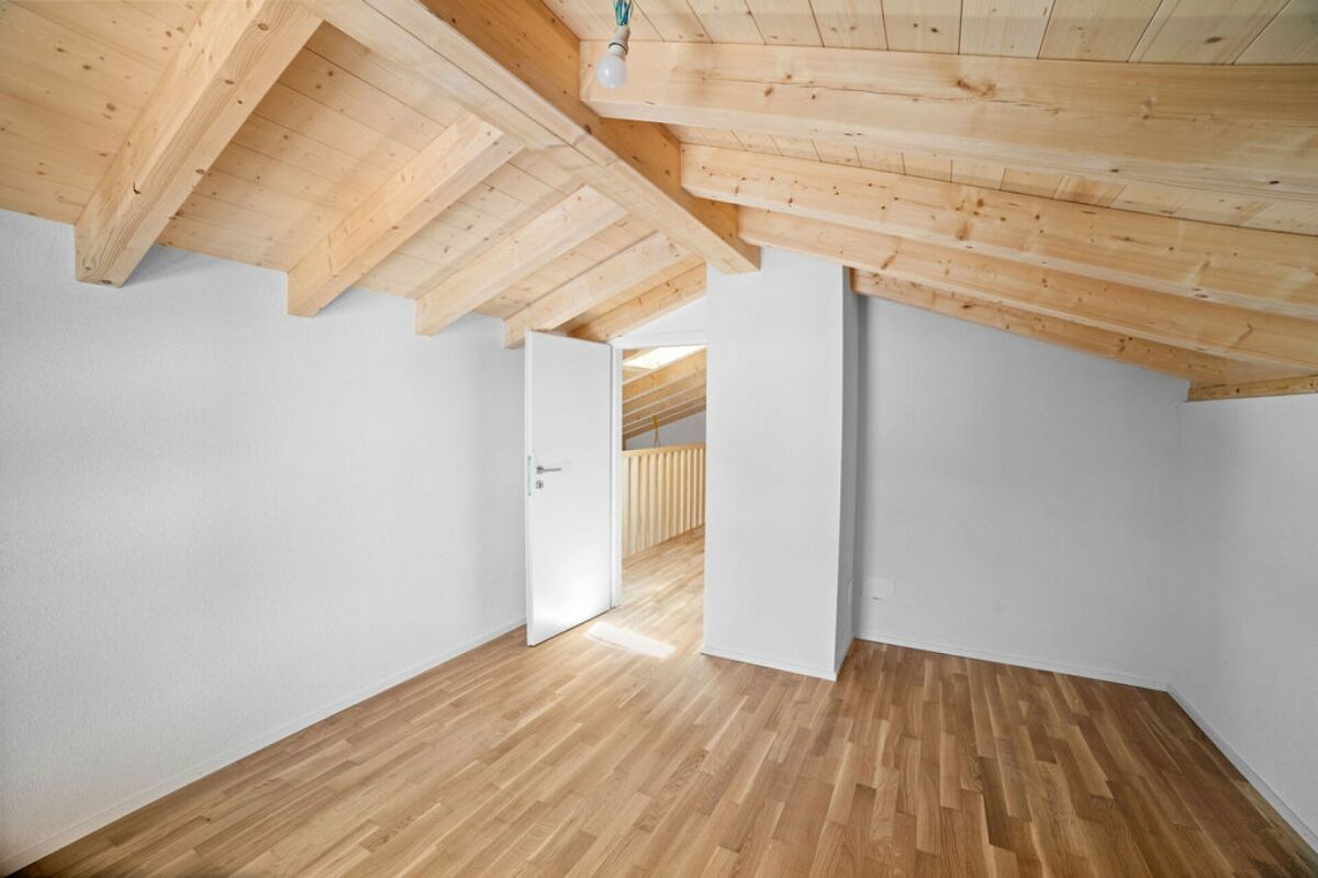 Dachgeschosszimmer mit sichtbaren Holzbalken
