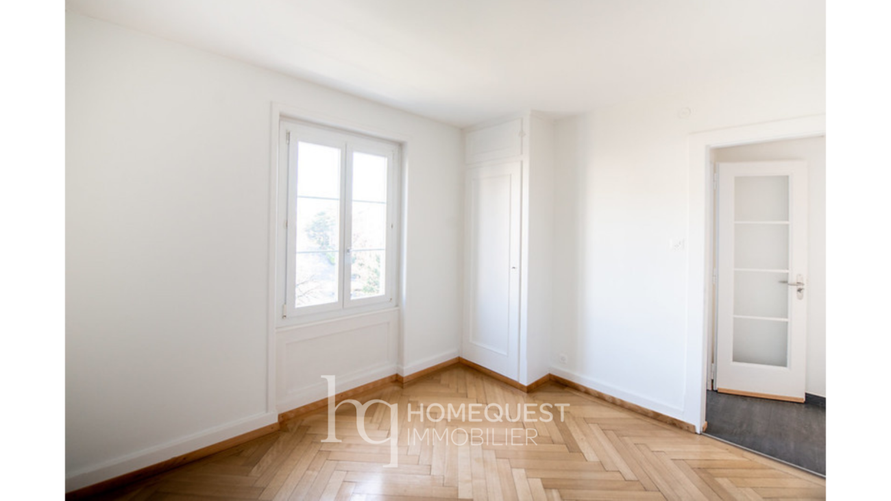 Helles, leerstehendes Zimmer mit Parkett und weißem Einbauschrank