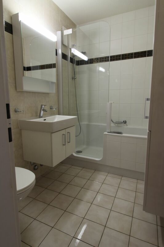 Modernes Badezimmer mit Wanne und Glasabtrennung